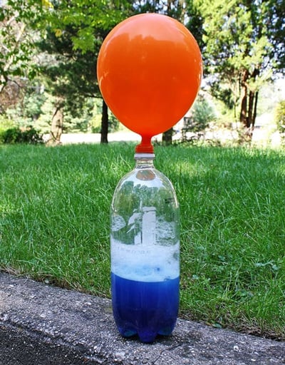 2 litrelik bir şişenin üzerindeki kırmızı balon, şişenin içinde açığa çıkan gazlar sayesinde havayla doluyor.